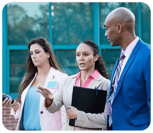 Man standing with two women, discussing a something.