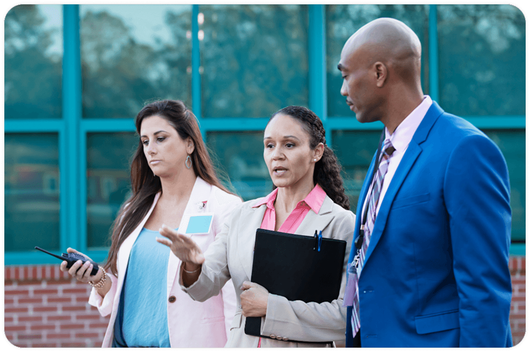 Man standing with two women, discussing a something.
